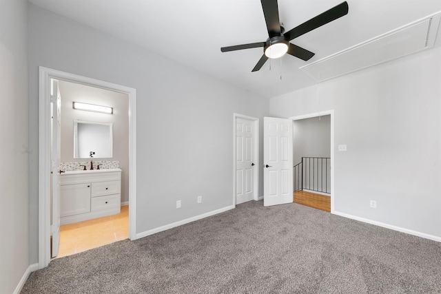 unfurnished bedroom with ensuite bathroom, light colored carpet, ceiling fan, and sink