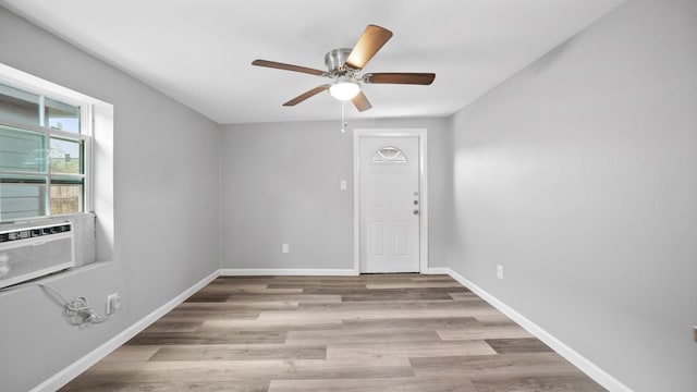 empty room with light hardwood / wood-style floors, cooling unit, and ceiling fan