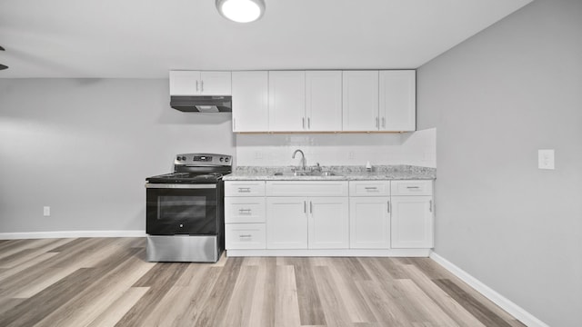 kitchen with stainless steel electric range oven, white cabinets, light stone counters, and sink