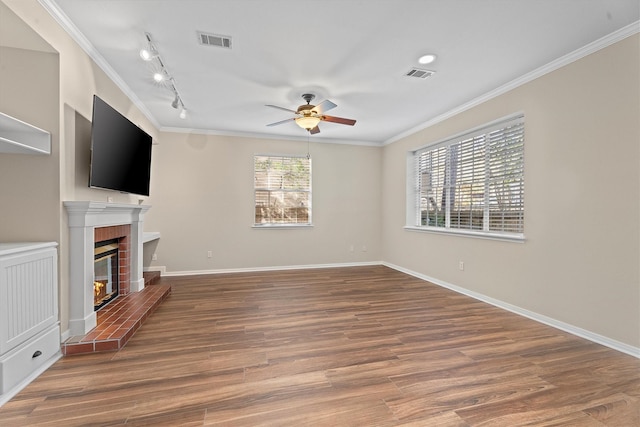 unfurnished living room featuring crown molding, hardwood / wood-style flooring, a fireplace, and ceiling fan