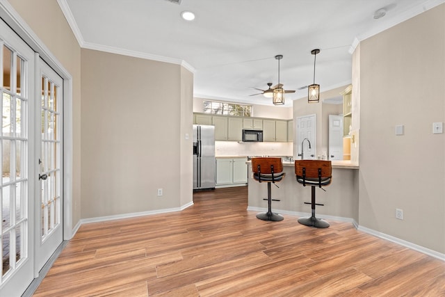 kitchen featuring decorative light fixtures, a breakfast bar, light hardwood / wood-style floors, and stainless steel fridge with ice dispenser