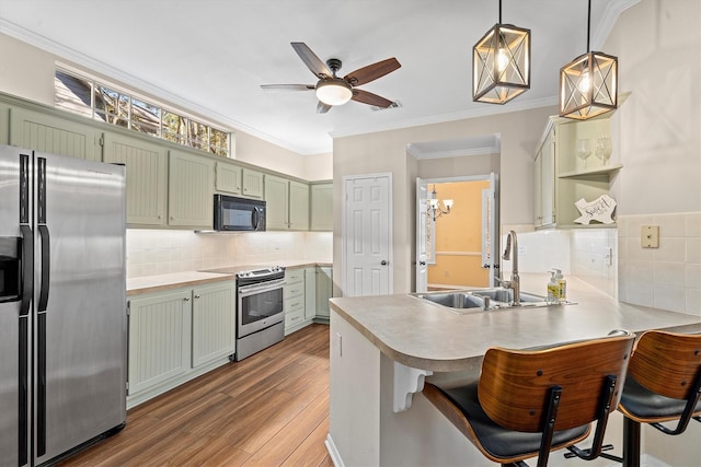 kitchen featuring green cabinetry, stainless steel appliances, a kitchen bar, and kitchen peninsula