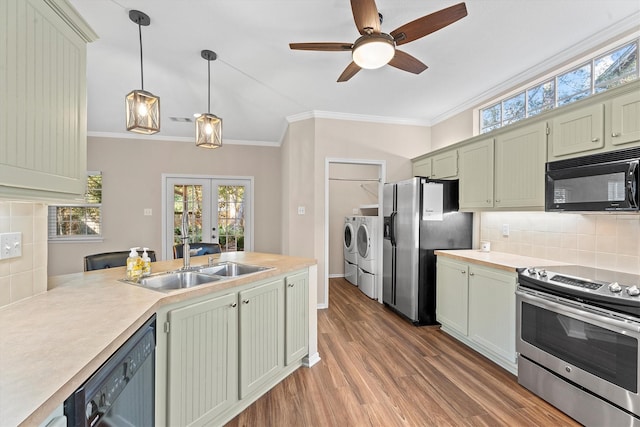 kitchen with sink, decorative backsplash, ornamental molding, black appliances, and washing machine and dryer