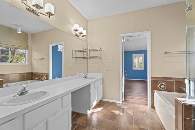 bathroom with vanity, tiled bath, and tile patterned flooring