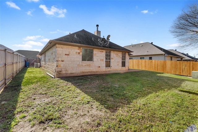 rear view of property featuring a yard and central AC