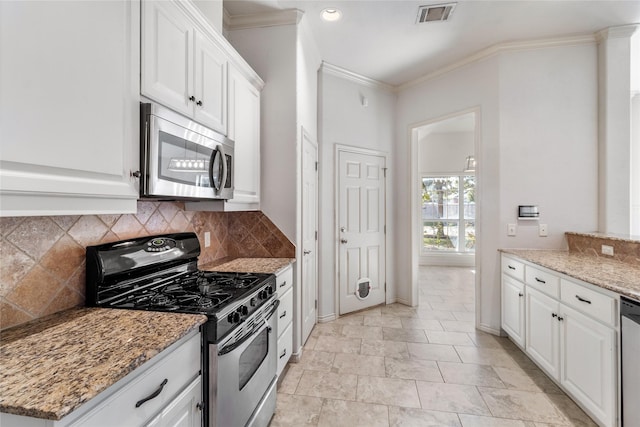 kitchen featuring light stone countertops, white cabinets, backsplash, and appliances with stainless steel finishes