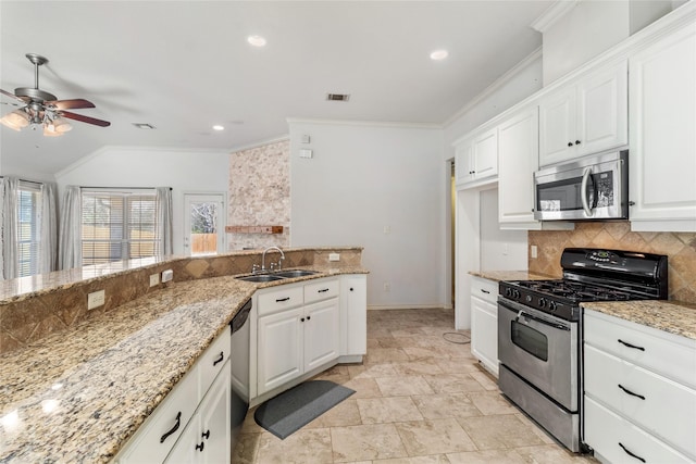 kitchen featuring backsplash, sink, white cabinetry, light stone countertops, and appliances with stainless steel finishes