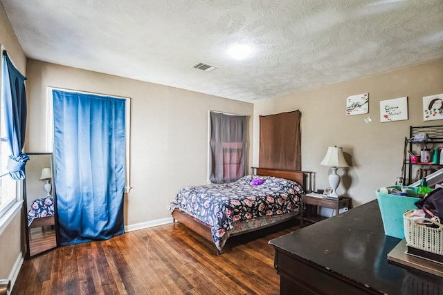 bedroom featuring dark hardwood / wood-style floors and a textured ceiling