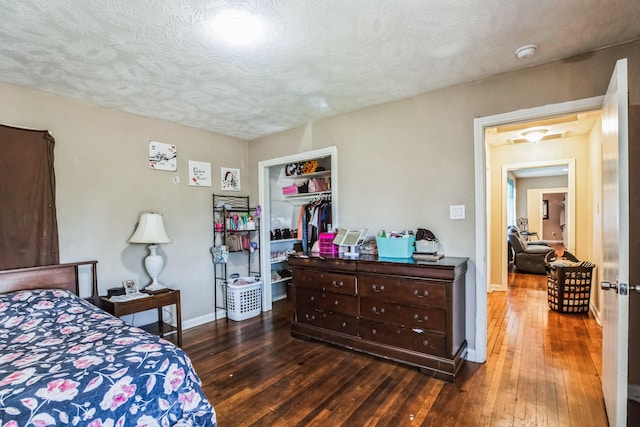 bedroom featuring a textured ceiling, a closet, and dark hardwood / wood-style flooring