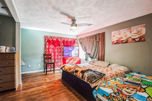 bedroom with a textured ceiling, ceiling fan, and hardwood / wood-style flooring