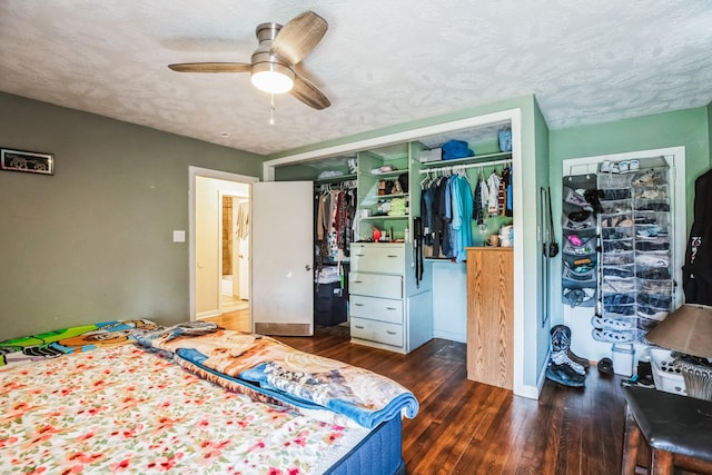 bedroom featuring a textured ceiling, a closet, dark wood-type flooring, and ceiling fan