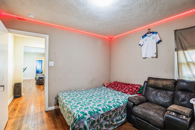 bedroom featuring wood-type flooring and a textured ceiling