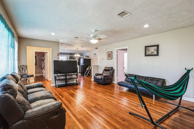 living room featuring a textured ceiling, ceiling fan, and hardwood / wood-style floors