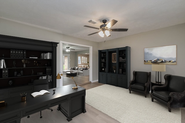 home office featuring ceiling fan and light hardwood / wood-style floors