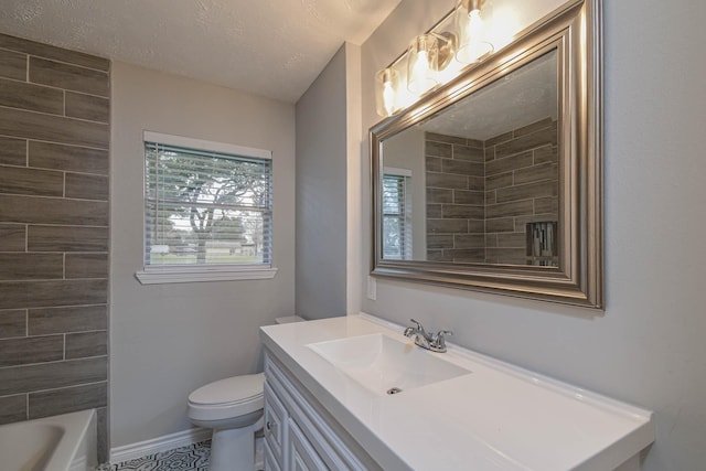 bathroom featuring a textured ceiling, toilet, and vanity