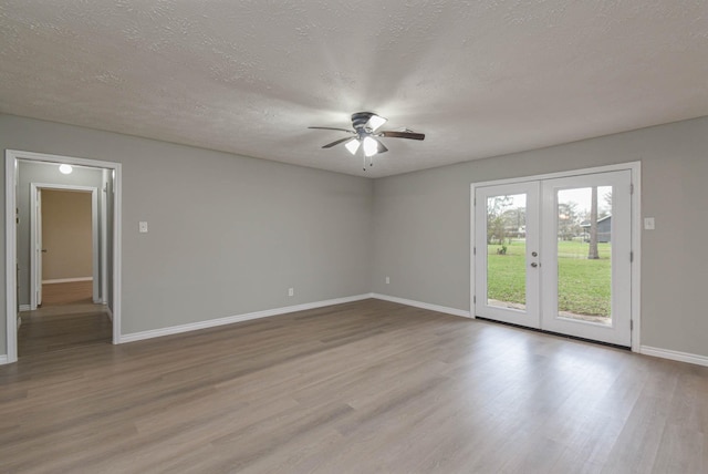 spare room featuring light wood-type flooring, ceiling fan, a textured ceiling, and french doors