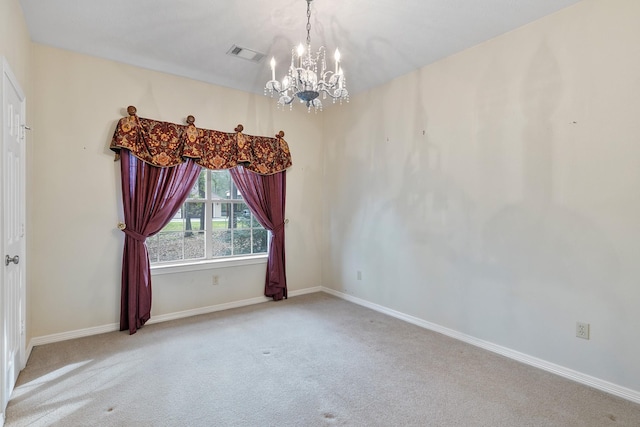 carpeted spare room featuring a notable chandelier