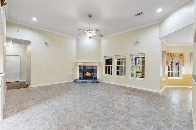 unfurnished living room with ceiling fan, a tile fireplace, and crown molding