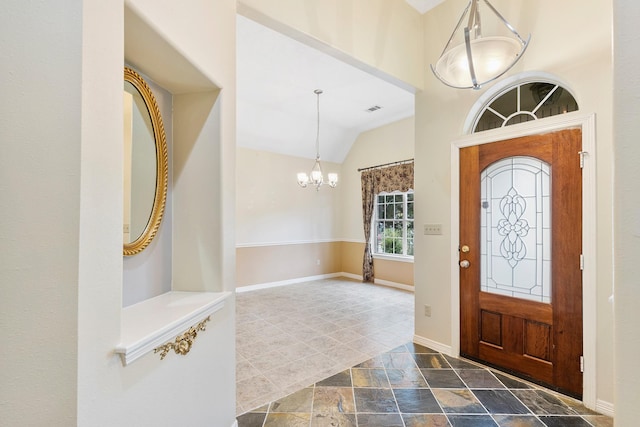 foyer entrance featuring a notable chandelier and vaulted ceiling