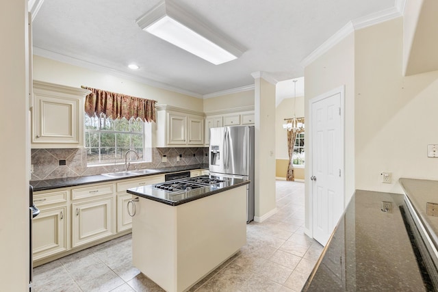 kitchen with a center island, stainless steel refrigerator with ice dispenser, sink, dark stone counters, and cream cabinets