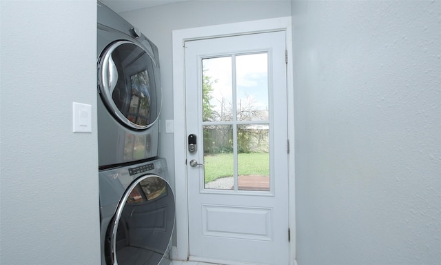 clothes washing area featuring stacked washer / dryer