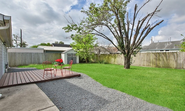 view of yard featuring a deck, a patio, and a storage unit