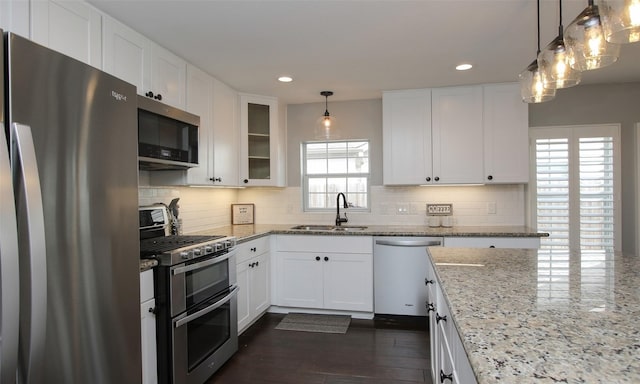 kitchen with appliances with stainless steel finishes, sink, and white cabinetry