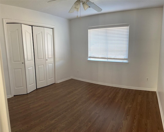 unfurnished bedroom with ceiling fan, dark hardwood / wood-style flooring, and a closet