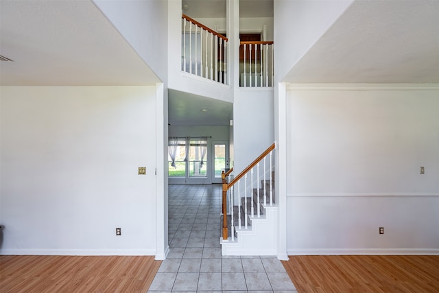 staircase with tile patterned flooring and a high ceiling