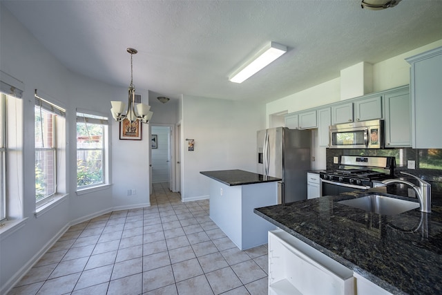 kitchen featuring pendant lighting, stainless steel appliances, sink, a notable chandelier, and light tile patterned flooring