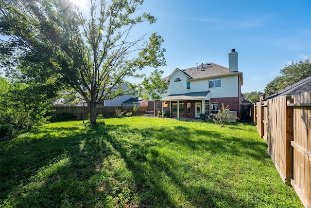 rear view of house featuring a yard