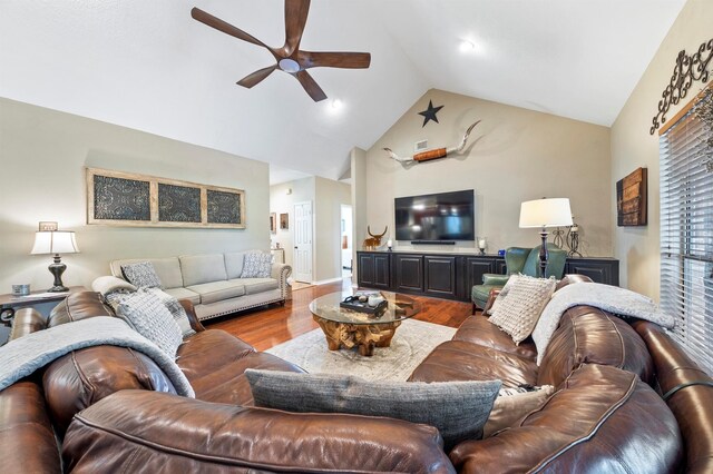 living room with ceiling fan, wood-type flooring, and vaulted ceiling