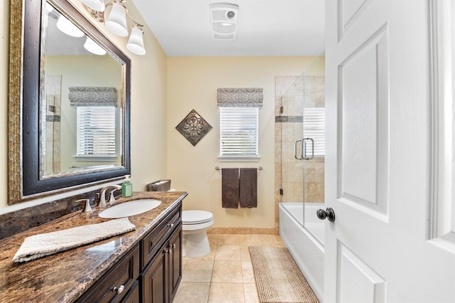 full bathroom featuring bath / shower combo with glass door, tile patterned floors, vanity, and toilet