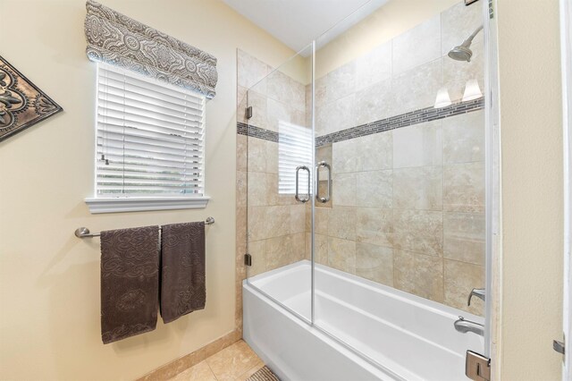 bathroom featuring tile patterned floors, combined bath / shower with glass door, and a wealth of natural light