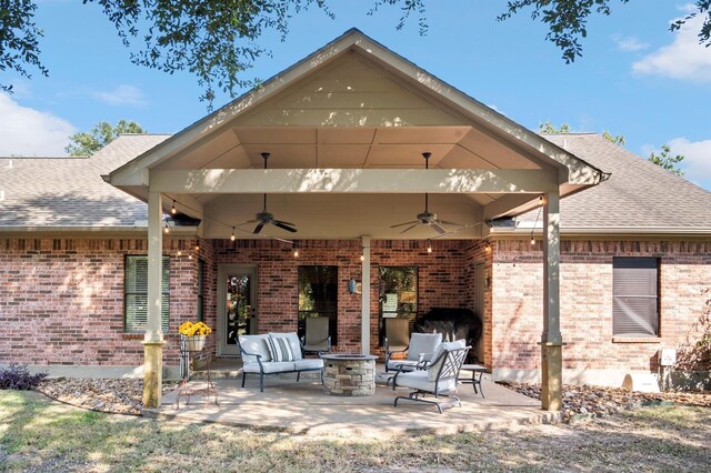 view of patio featuring ceiling fan and an outdoor living space with a fireplace