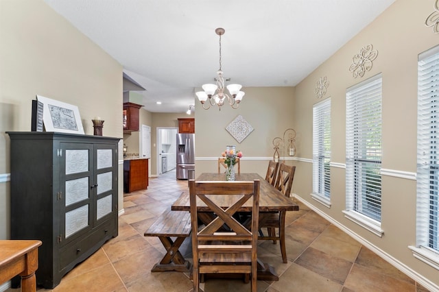 tiled dining area featuring a chandelier