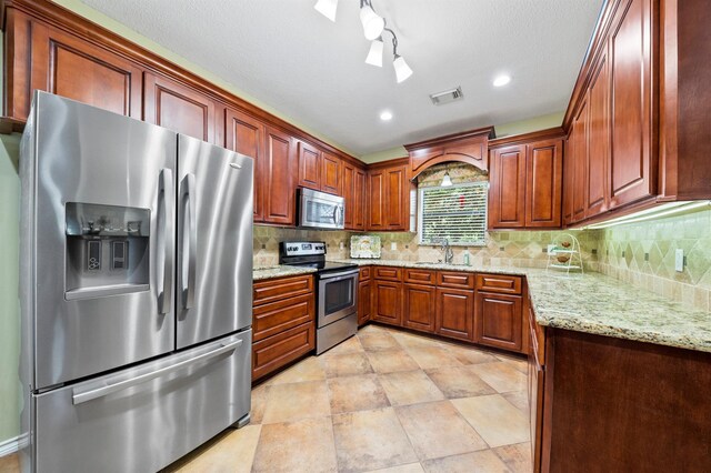 10403 W Hidden Lake Ln, Richmond, TX 77406 - kitchen with stainless steel appliances, a sink, tasteful backsplash, light stone countertops, and recessed lighting