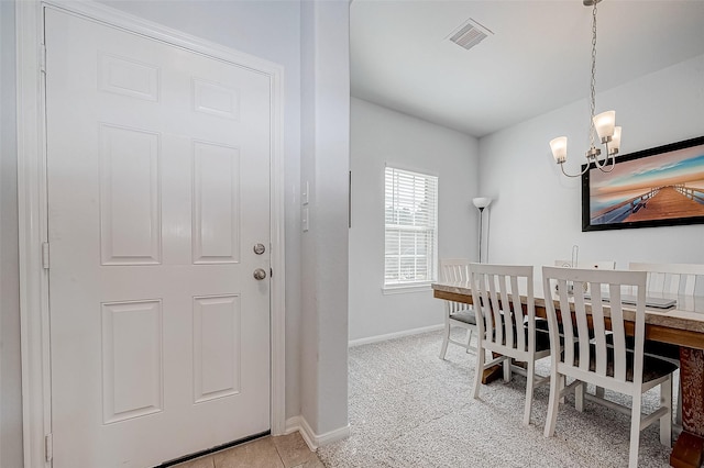 carpeted dining area featuring an inviting chandelier