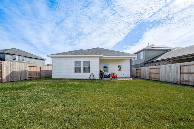 back of property with a lawn and a patio area