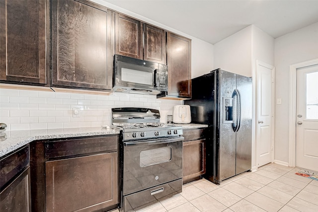 kitchen featuring tasteful backsplash, black appliances, dark brown cabinetry, light tile patterned floors, and light stone counters