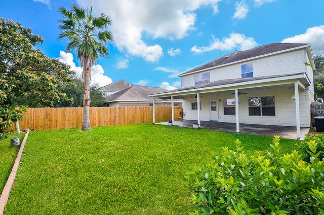 rear view of house featuring a yard and a patio