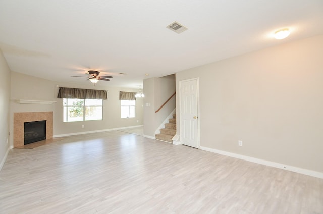 unfurnished living room with a fireplace, ceiling fan, and light hardwood / wood-style flooring