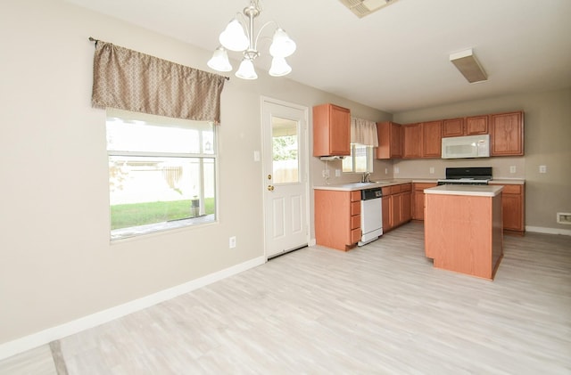 kitchen with pendant lighting, dishwasher, a center island, range, and a notable chandelier