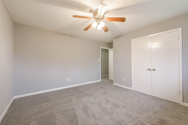 unfurnished bedroom featuring ceiling fan, a closet, and carpet floors