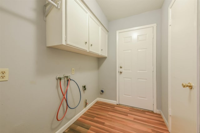 clothes washing area with washer hookup, cabinets, electric dryer hookup, and light hardwood / wood-style floors