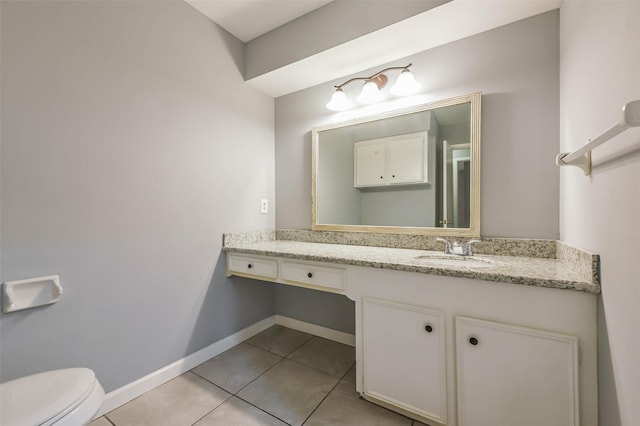 bathroom featuring toilet, vanity, and tile patterned flooring