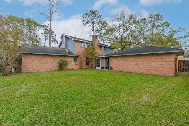 rear view of property featuring a yard