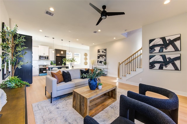 living room featuring ceiling fan and light hardwood / wood-style floors