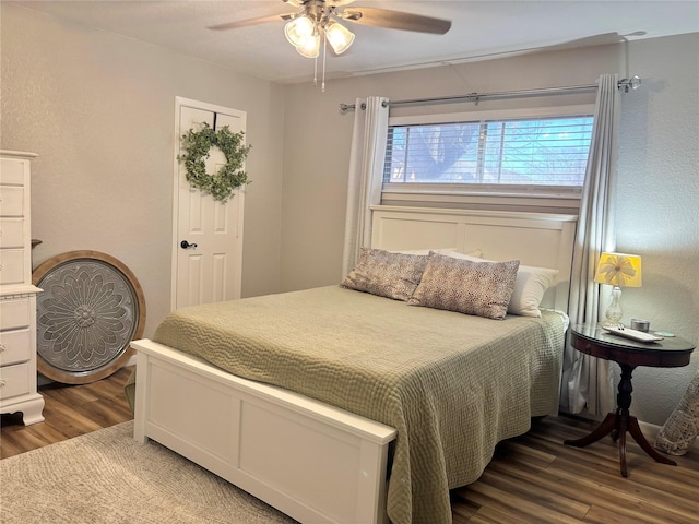 bedroom with dark hardwood / wood-style flooring and ceiling fan