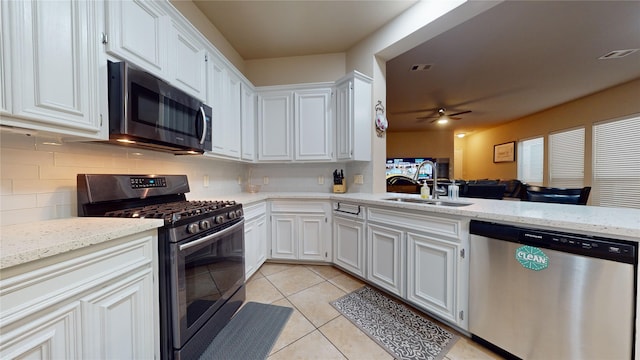 kitchen featuring white cabinetry, stainless steel appliances, sink, and light tile patterned floors